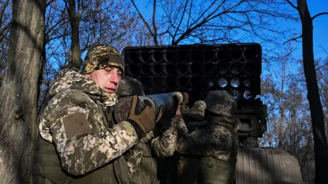 Soldiers of the 152nd Jaeger Brigade of the Ukrainian Armed Forces load a shell into a BM-21 Grad multiple rocket launch system at their front line position.