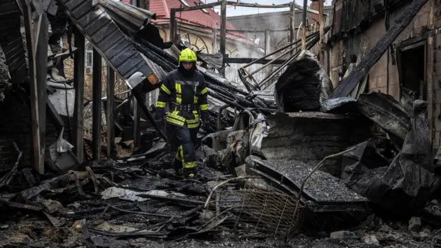 A firefighter walks through Kyiv destroyed house