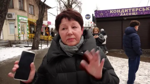 Kyiv resident Tetiana speaks to reporter off camera. She's wearing a thick black coat and snow can be seen on the ground around her.