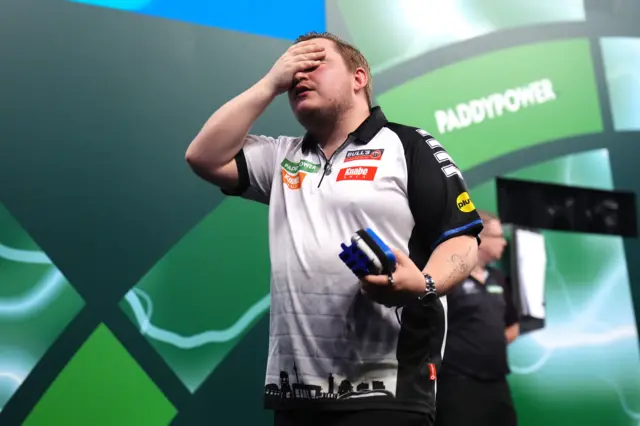 Germany's Martin Schindler reacts following defeat in his match against England's Ryan Searle (not pictured) on day fifteen of the Paddy Power World Darts Championship at the Alexandra Palace, London