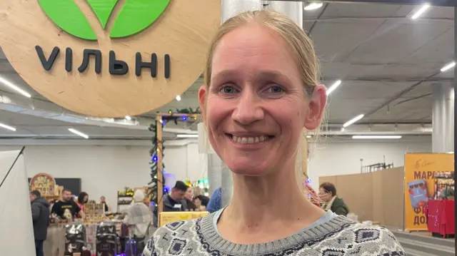 Helen Petukhova smiles in an indoor market
