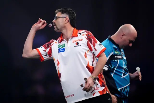 Australia's Damon Heta (left) during his match against England's Rob Cross on day fifteen of the Paddy Power World Darts Championship at the Alexandra Palace, London