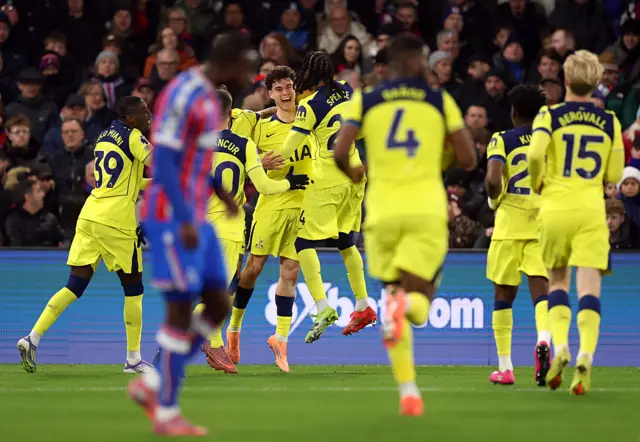 Gray jumps in the air in jubilation as teammates run to celebrate his goal