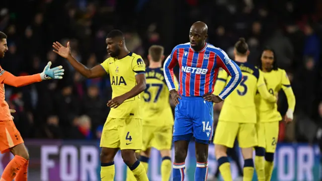 Mateta looks at the floor as Tottenham players celebrate behind