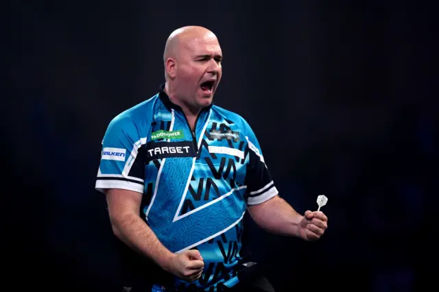 England's Rob Cross celebrates a second set during his match against England's Luke Littler on day sixteen of the Paddy Power World Darts Championship at the Alexandra Palace, London