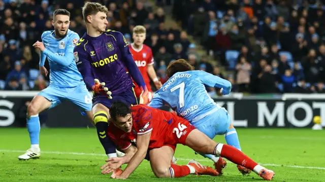 Ipswich's Jacob Greaves falls to the ground under the challenge of Coventry keeper Carl Rushworth