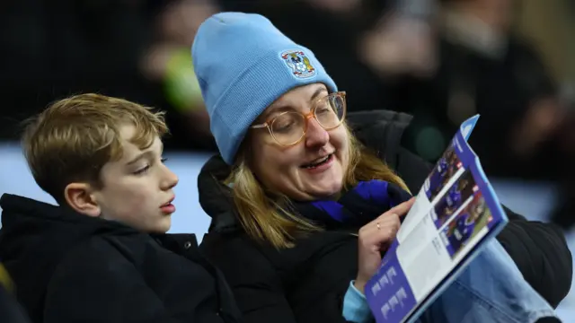 Coventry fans read the matchday programme