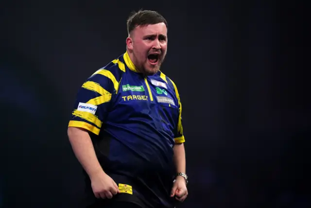 England's Luke Littler celebrates winning a set during his match against England's Rob Cross on day sixteen of the Paddy Power World Darts Championship at the Alexandra Palace, London