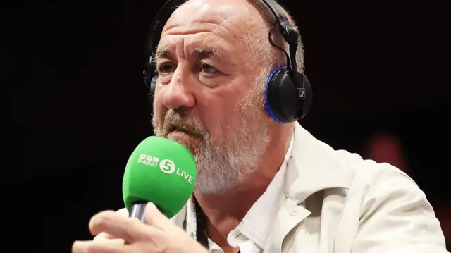 Steve Bunce ringside with a 5 Live microphone and a headset