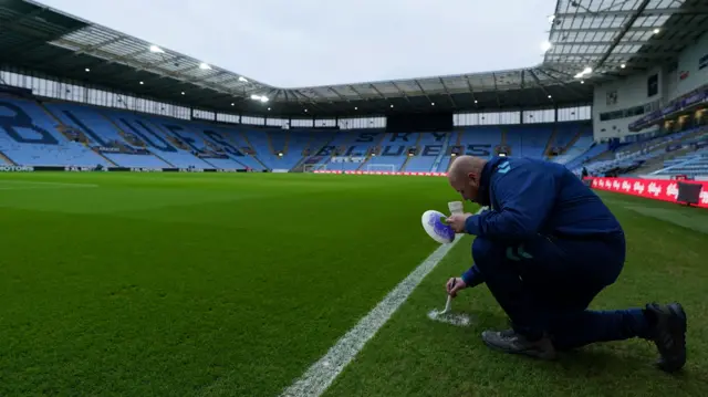 A member of the Coventry groundstaff touches up a line at the CBS Arena