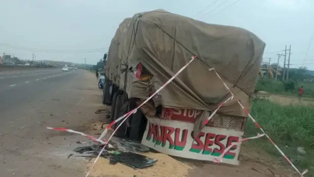 A truck with a pile of sand and debris around it