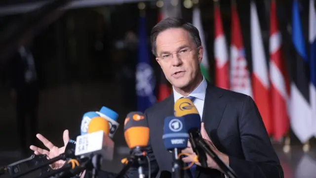 Nato chief Mark Rutte speaks at a press conference with several microphones in front of him.