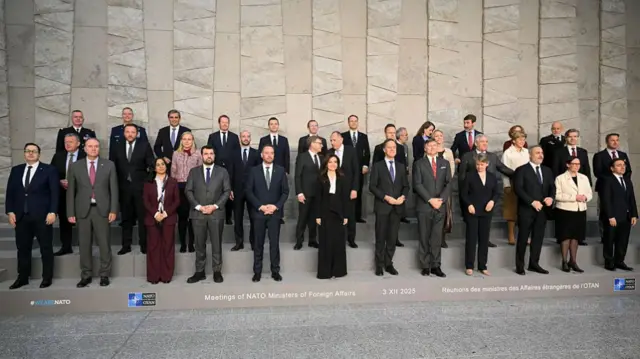 NATO Secretary General Mark Rutte (C-R) and participants pose for a family photograph following a meeting of NATO Ministers of Foreign Affairs at NATO headquarters in Brussels on December 3, 2025.