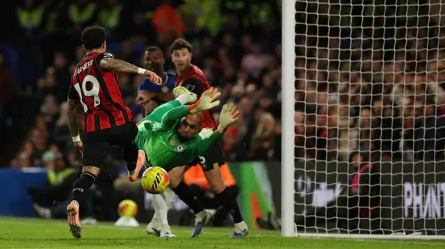 Justin Kluivert (L) pokes the ball past a diving Robert Sanchez