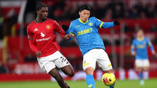 Hwang Hee-Chan battles for possession with Ayden Heaven