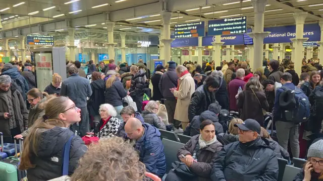 A crowd of people in St Pancras station near the Eurostar terminal