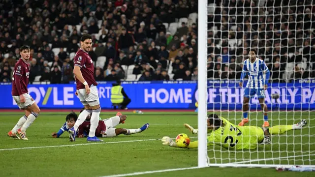 Alphonse Areola of West Ham United makes a save from Kaoru Mitoma of Brighton