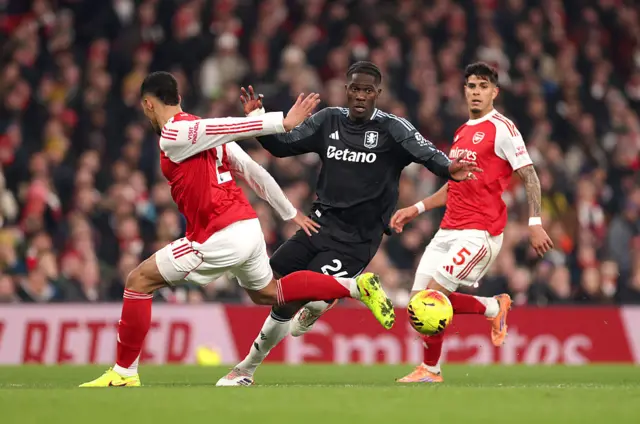 Amadou Onana of Aston Villa is challenged by William Saliba of Arsenal
