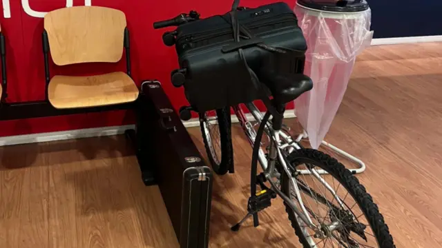 A suitcase is strapped to a bike