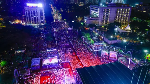 A large crowd fills a street