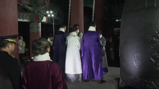 People in Seoul ringing a large bell