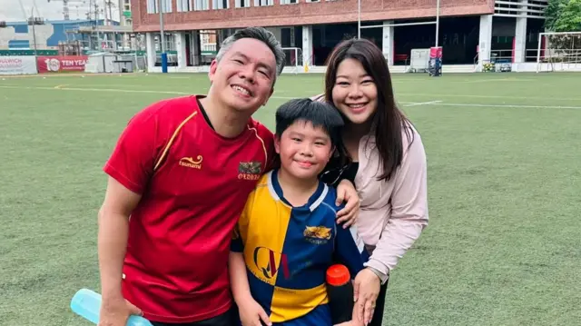 Singapore family pose together on rugby field