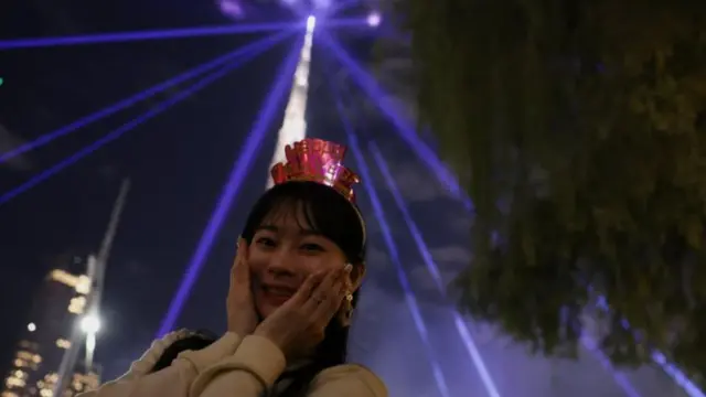 A reveller stands in front of Burj Khalifa, the world's tallest building