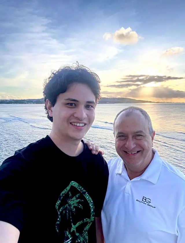 Mark Baldyga puts his arm around his son Michael. Both men smile