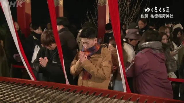 Two people in focus, holding their hands together in prayer