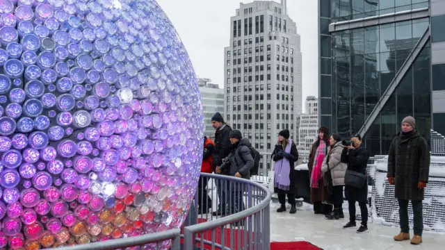 People look at the Times Square New Year's Eve Ball on the roof of One Times Square building in New York