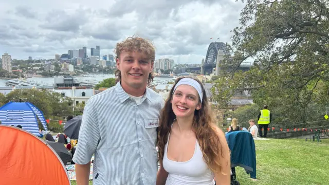 Joe wearing a stripped shirt pictured with Lucy who is wearing a white top