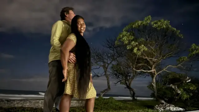 Bryant and Waata pose together on a beach