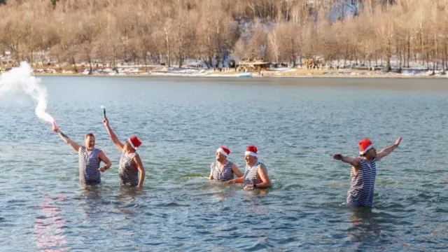 People celebrate the new year early at noon, on New Year's Eve, by Lake Bajer, in Fuzine, Croatia, December 31, 2025.
