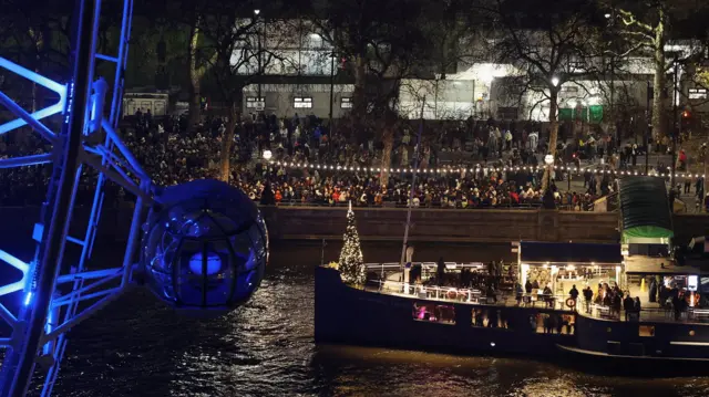 People are seen gathering along banks of the Thames in London.