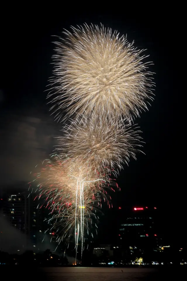 Yellow fireworks bloom in the sky in Hanoi