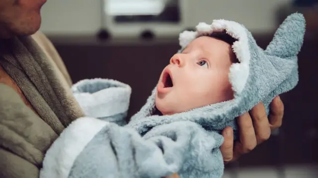 A baby held by a parent.