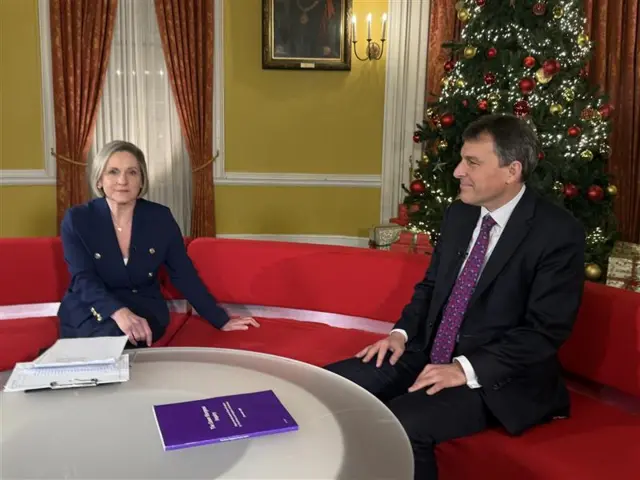 Amanda Parr and John Glen sitting on a red sofa