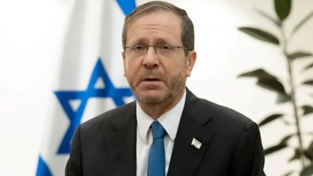 A file photo of Isaac Herzog in front of an Israeli flag