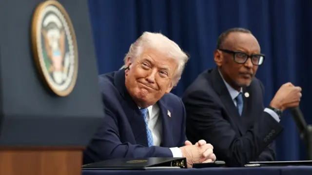 A smiling Donald Trump sitting next to Rwandan President Paul Kagame