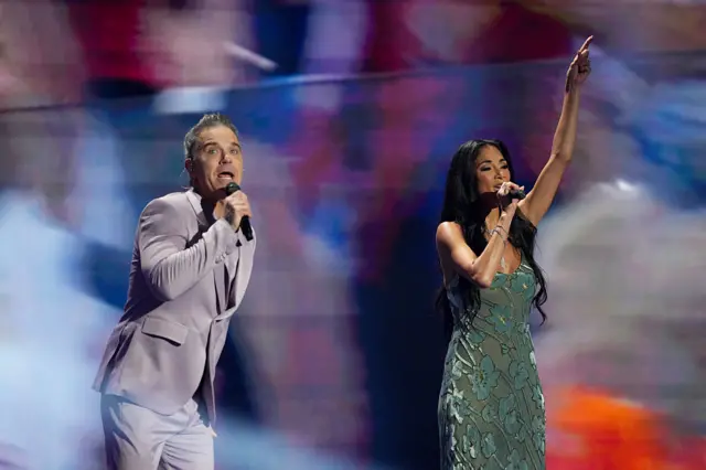 British Singer songwriter Robbie Williams and US singer Nicole Scherzinger perform on stage during the draw for the 2026 FIFA Football World Cup taking place in the US, Canada and Mexico, at the Kennedy Center, in Washington, DC, on December 5, 2025.