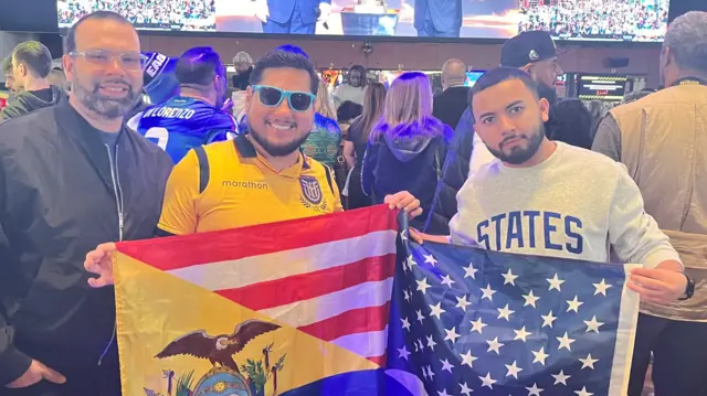 Three football fans - two holding flags