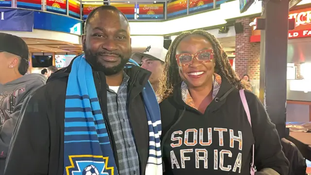 Two football fans wearing scarves and hoodies