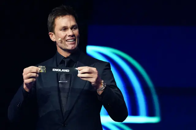 US Draw assistant Tom Brady shows the card reading France during the draw for the 2026 FIFA Football World Cup taking place in the US, Canada and Mexico, at the Kennedy Center, in Washington, DC, on December 5, 2025.
