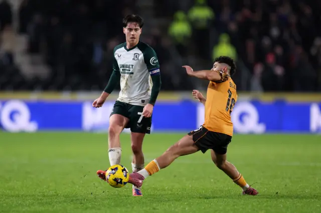 Hayden Hackney of Middlesbrough passes the ball whilst under pressure from Mohamed Belloumi of Hull City