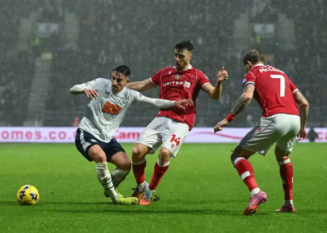 Preston North End's Pol Valentin holds off a challenge from Wrexham's George Thomason