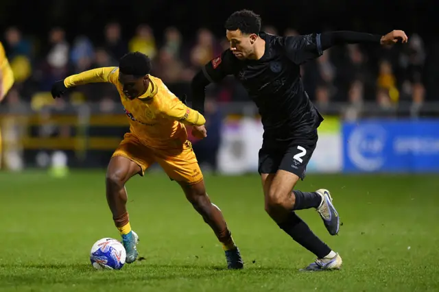David Ogbonna of Sutton United vies for the ball with Luca Hoole of Shrewsbury Town