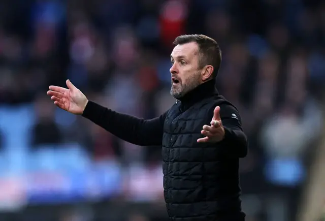 Nathan Jones holds his hands outstretched
