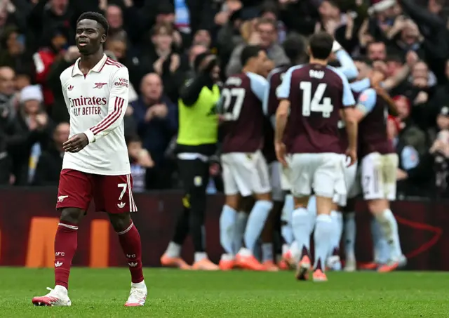Bukayo Saka reacts as Aston Villa's Polish defender #02 Matty Cash is mobbed by teammates after scoring the opening goal