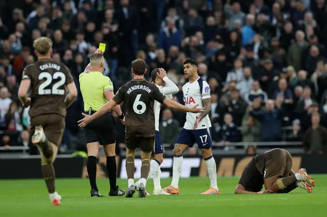 referee Rob Jones showing a yellow card