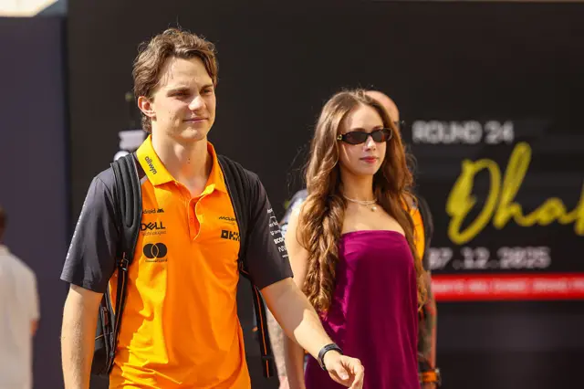 Oscar Piastri and his girlfriend, Lilly, walk into the paddock